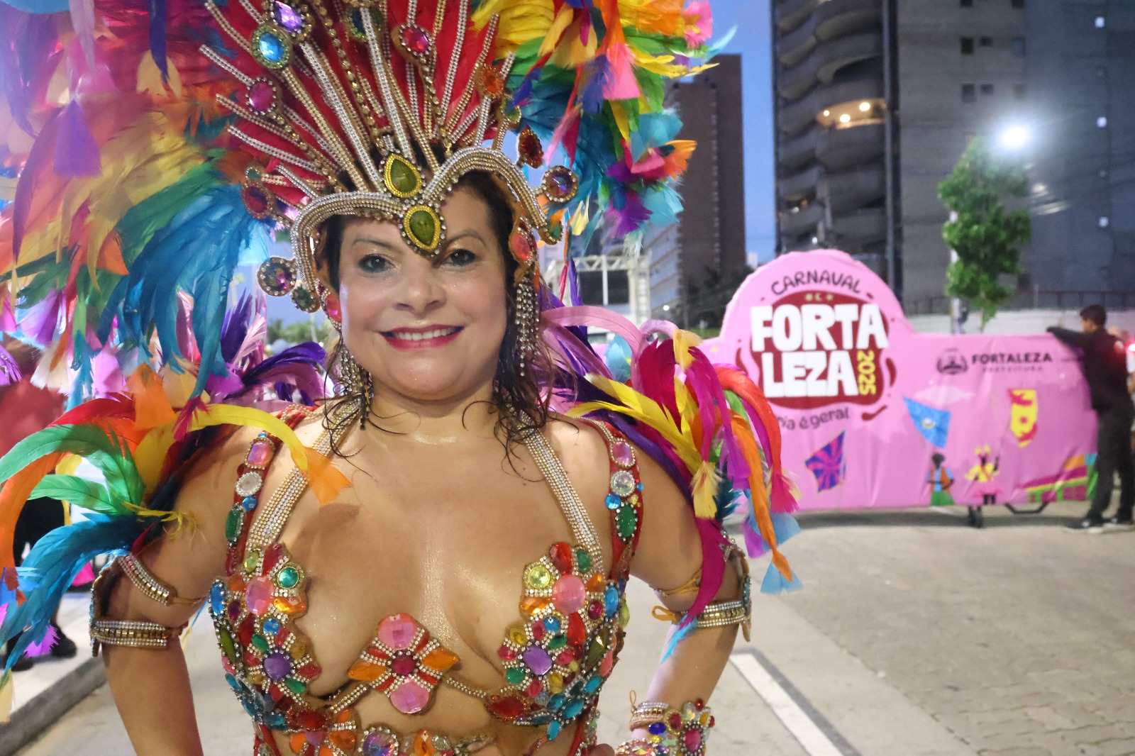 Antonella Mendes com uma fantasia dourada e um arranjo de cabeça também dourado